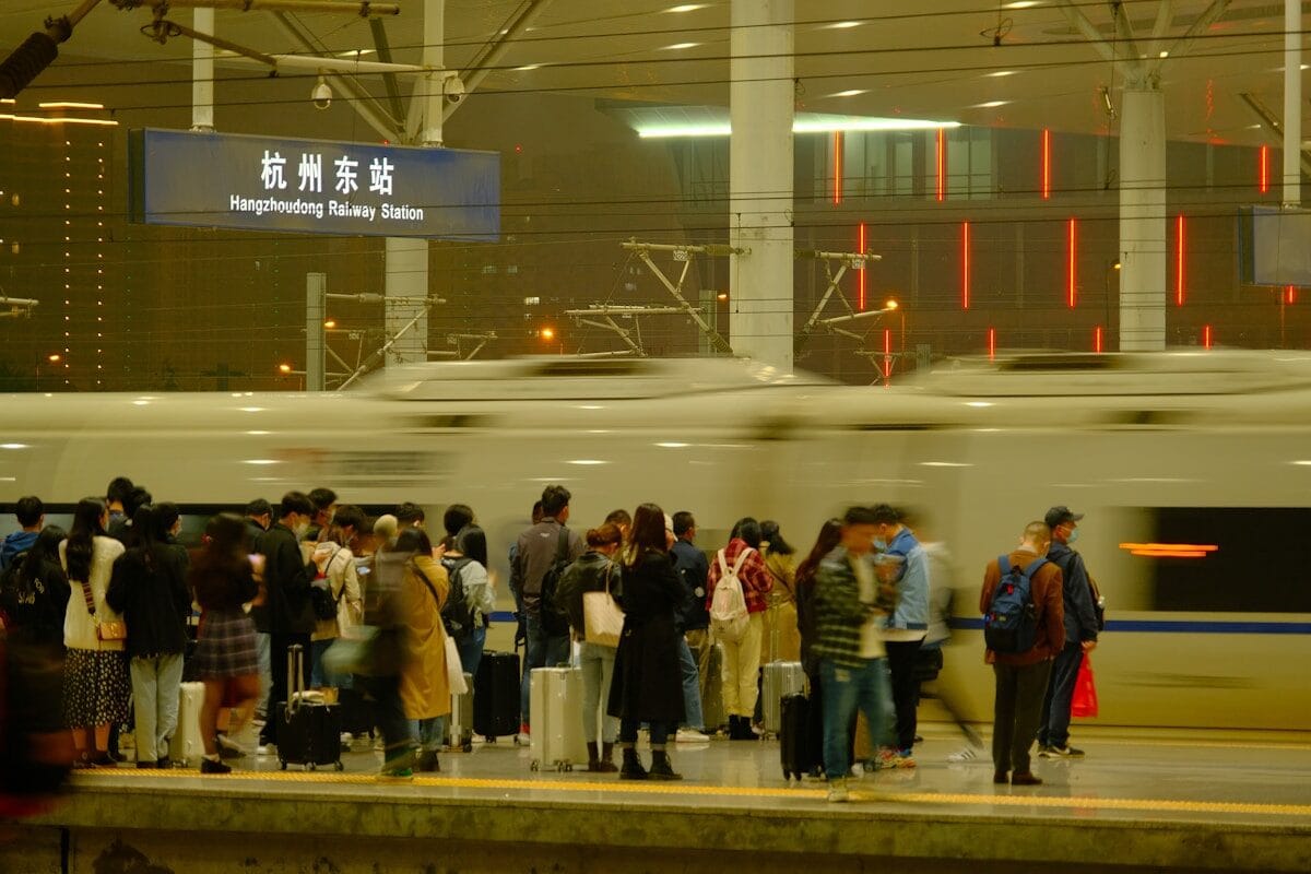 People Wait For A Train At A Railway Station.