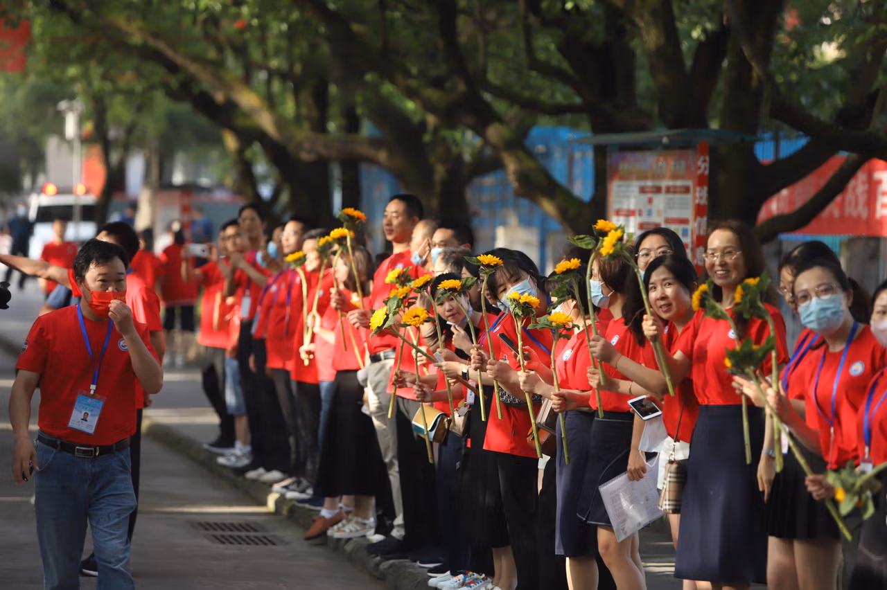 Teachers Held Sunflowers To Cheer On Students Taking The Gaokao.