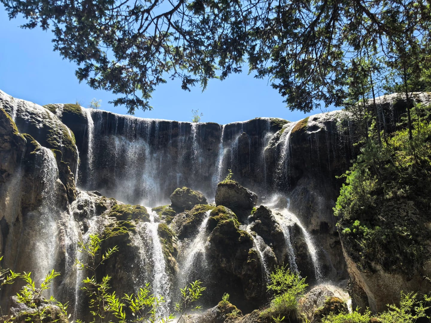 Majestic Waterfall Surrounded By Greenery.