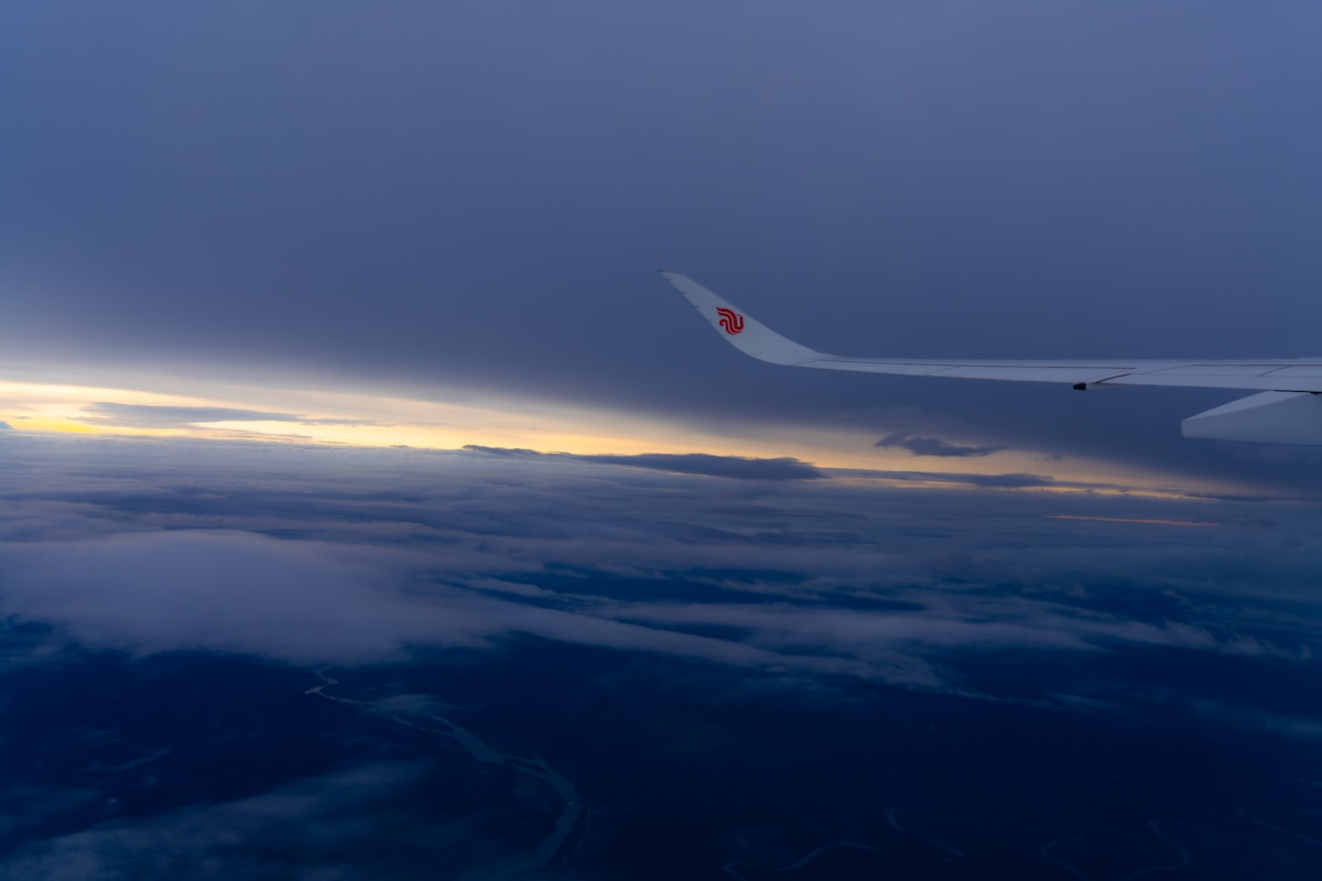 Airplane Wing Over Clouds At Sunset