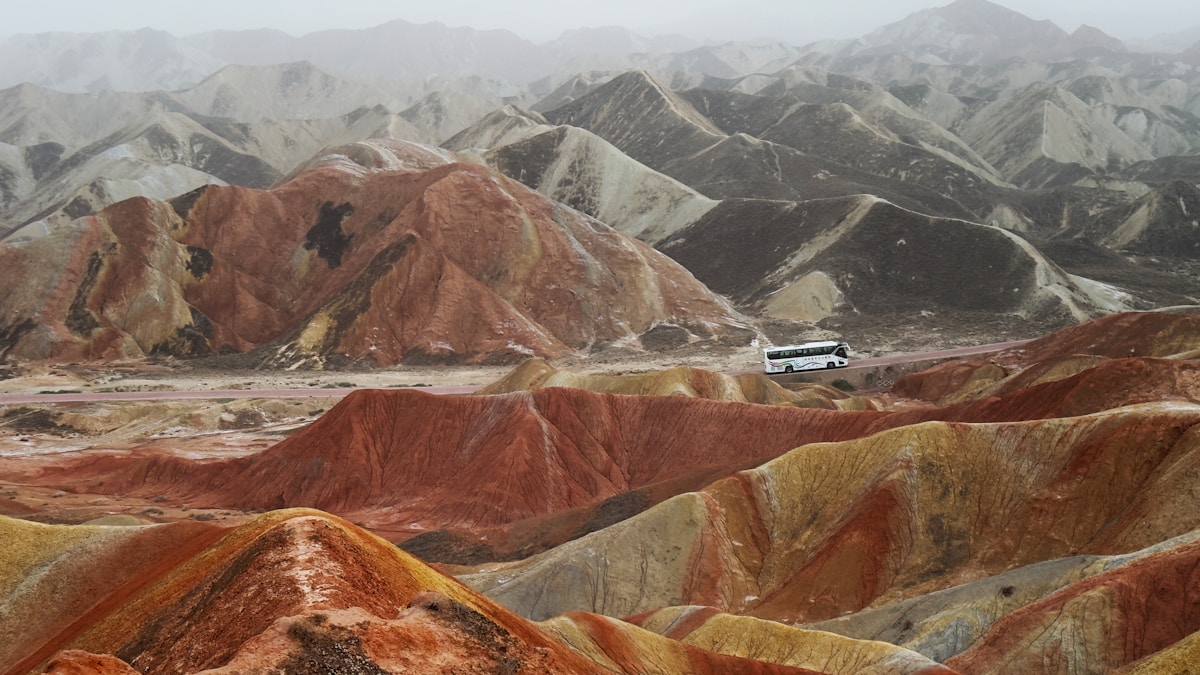 Zhangye National Geopark: The Ultimate Guide To Rainbow Mountains Of China 15 Colorful Mountains With A Bus On The Horizon.